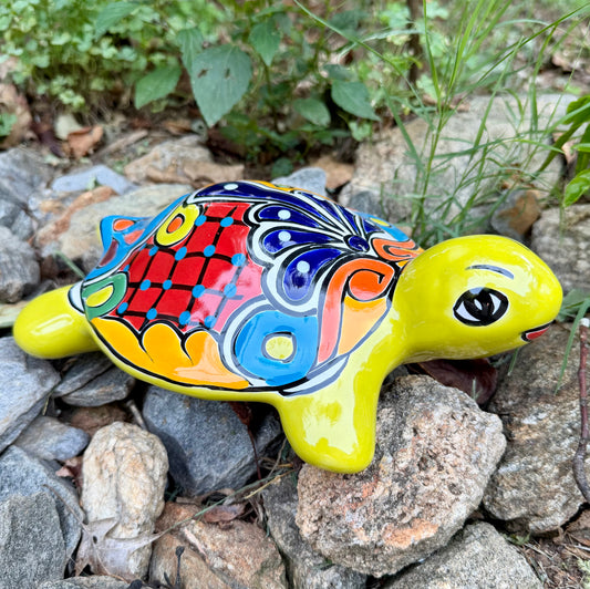 Colorful Mexican Talavera ceramic turtle figurine on a natural stone background