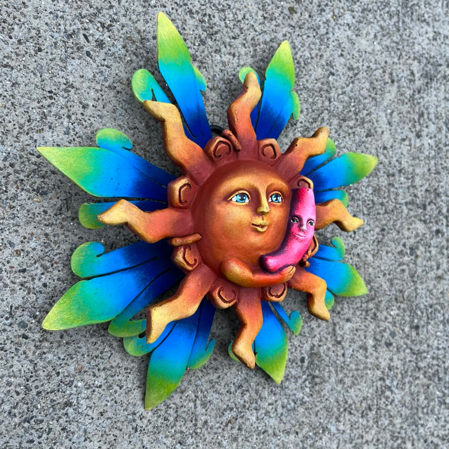 Sun holding pink moon metal art side