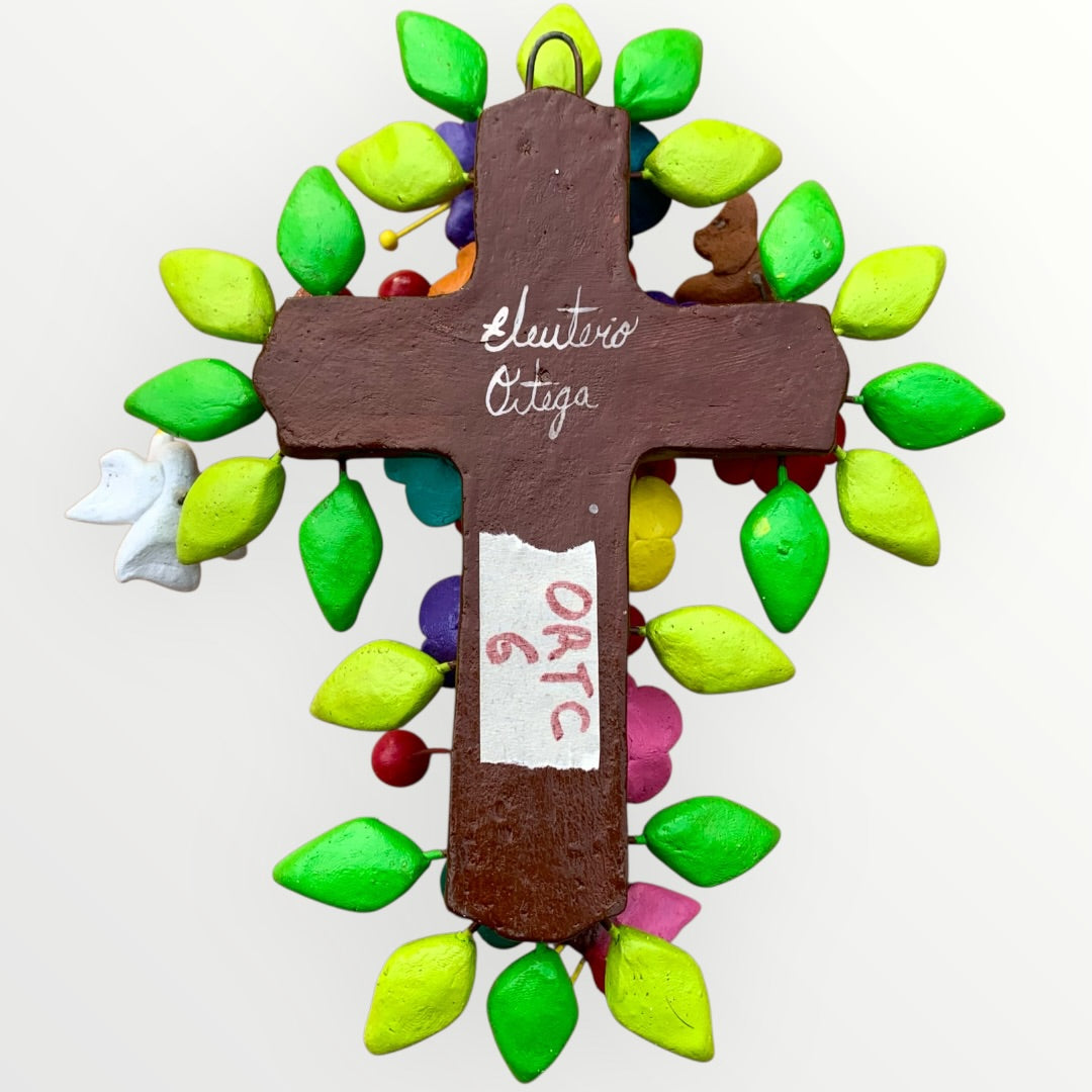 Ortega Family Folk Art Cross with colorful flowers, leaves, birds and butterflies. Cross base is cafe color, signed cross back