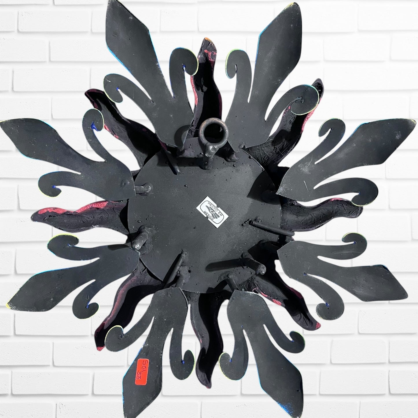 Back of metal sun wall art showing loop for hanging