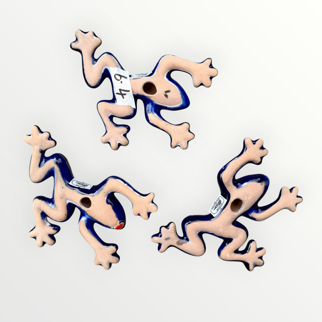 Three colorful ceramic frogs on a white background Back view