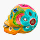 Colorful Mexican Sugar skull yellow with vibrant designs on a white background side view