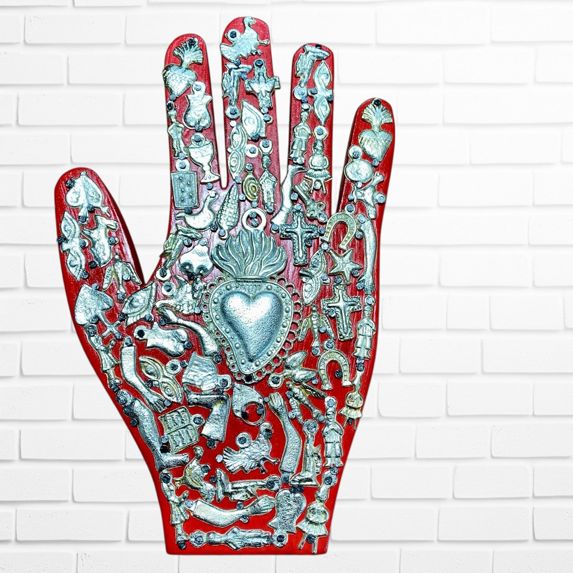 Decorative palm with intricate silver designs on a white brick wall background red