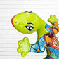 A colorful decorative lizard Talavera wall sculpture with a hand-painted floral and geometric pattern, mounted against a white brick wall, close-up of face and eyes.