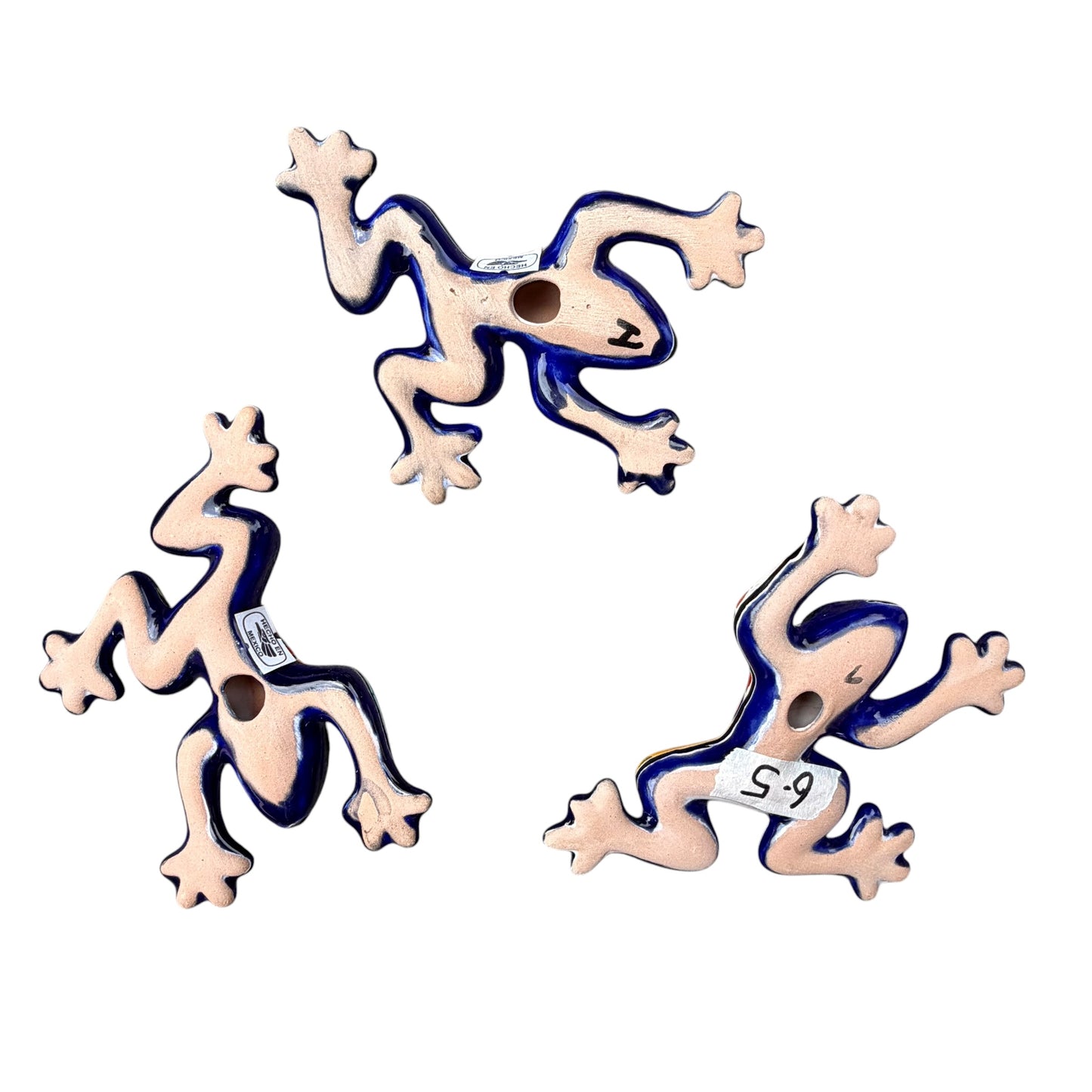 Three colorful ceramic frogs on a white background Back ground