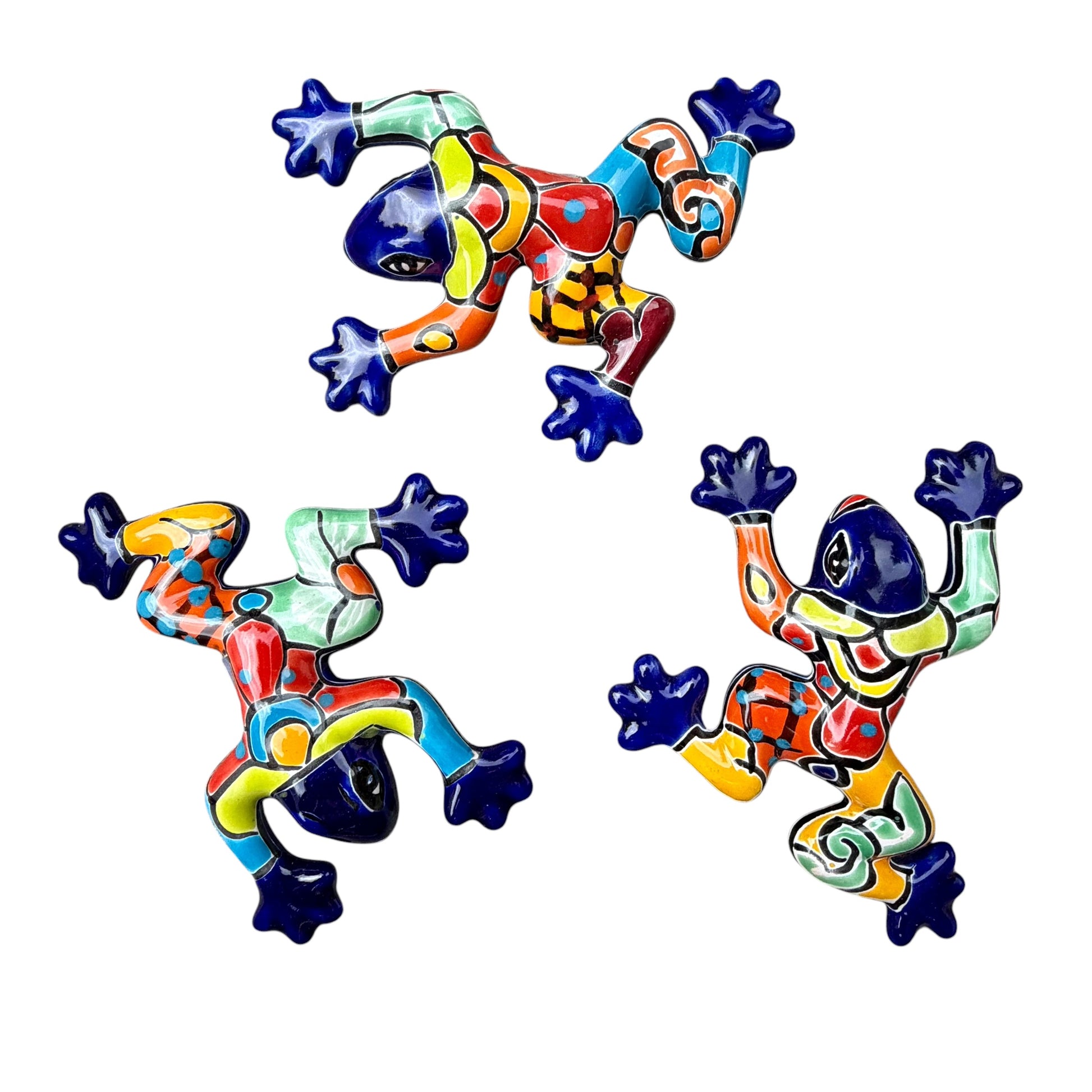 Three colorful ceramic frogs on a white background