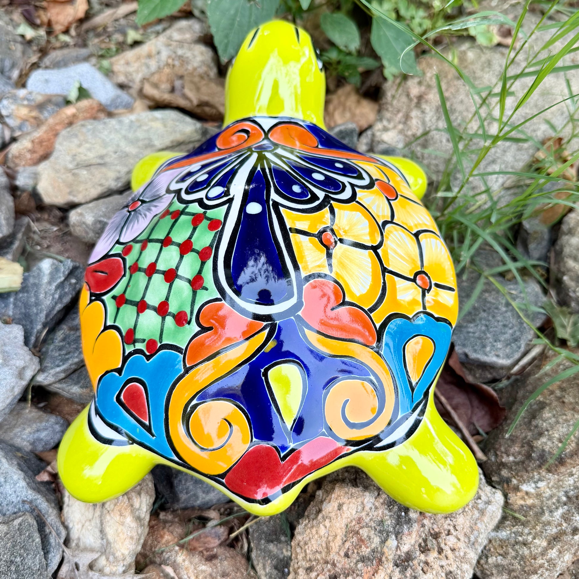 Mexican Talavera Colorful turtle-shaped object on a rocky surface Back view
