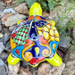 Mexican Talavera Colorful turtle-shaped object on a rocky surface Back view