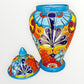 Colorful Mexican Talavera ceramic jar with lid decorated with intricate multicolor traditional patterns With lid off