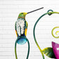 Decorative wall art with purple flowers and colorful hummingbirds on a white brick background top bird close up