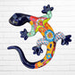 A colorful Mexican Talavera wall sculpture of a lizard, featuring a vibrant multicolor pattern with dark blue, orange, red, green, and yellow, mounted on a white brick wall.