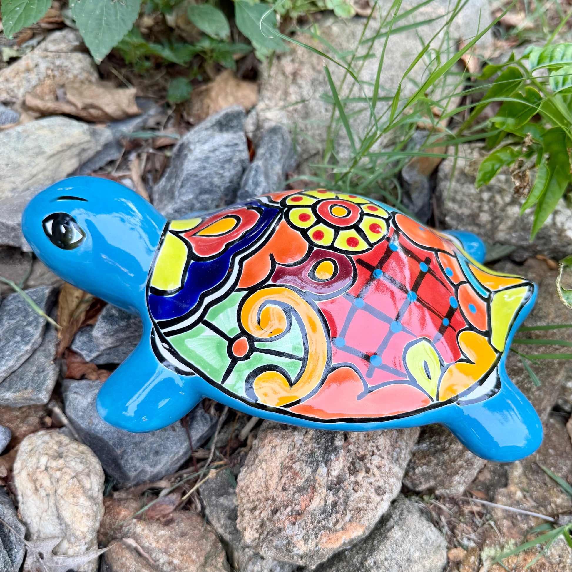 Colorful Mexican Talavera ceramic turtle figurine on a natural stone background Side