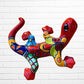 Colorful abstract dog sculpture against a white brick wall background left side view