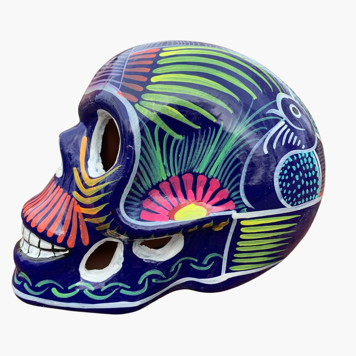 Colorful Mexican Sugar skull purple with vibrant designs on a white background Side view