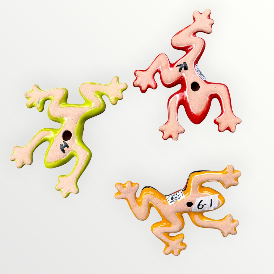 Three colorful ceramic frogs on a white background Back view