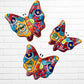 Three colorful talavera butterfly wall art pieces with orange and traditional multicolor patterns, displayed against a white brick wall. 