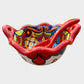 Colorful talavera salsa bowl with floral patterns and spoon on a white background Side view 