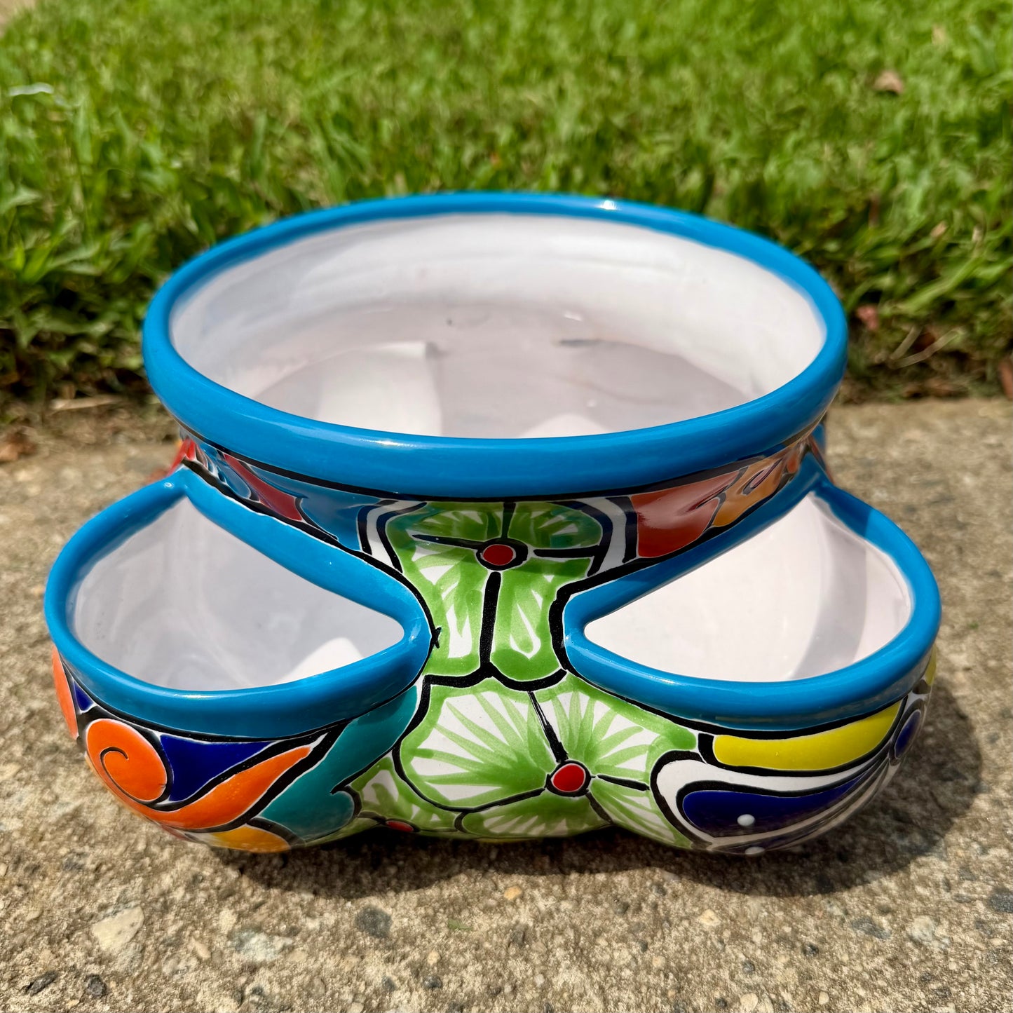 Hand painted Mexican Talavera Strawberry pot with a large top opening a four pockets on each side.  Trim color is turquoise body has multi-color designs. This is side view.