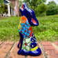 Coyote figurine on a brick surface with a garden background Side view