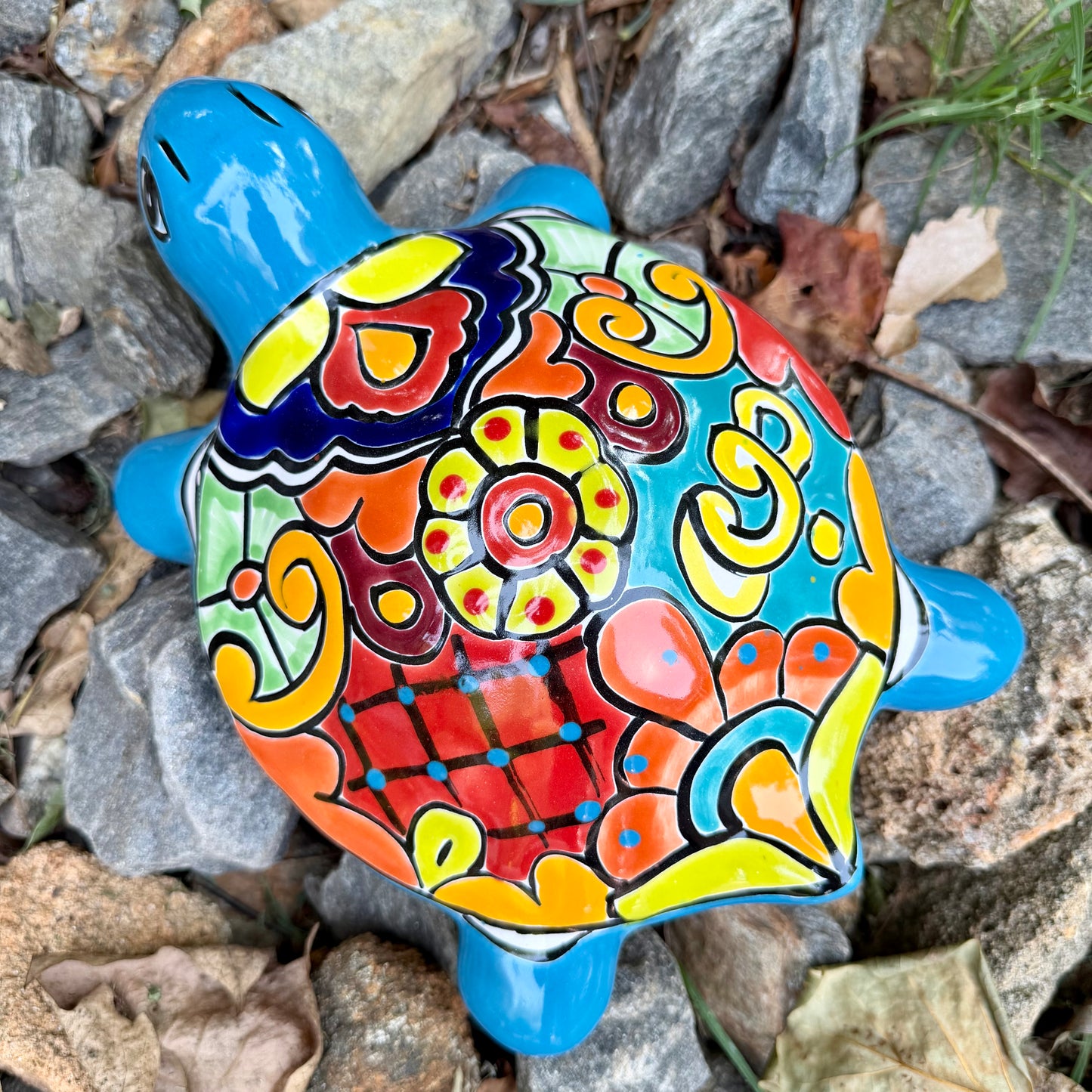 Colorful Mexican Talavera ceramic turtle figurine on a natural stone background Top