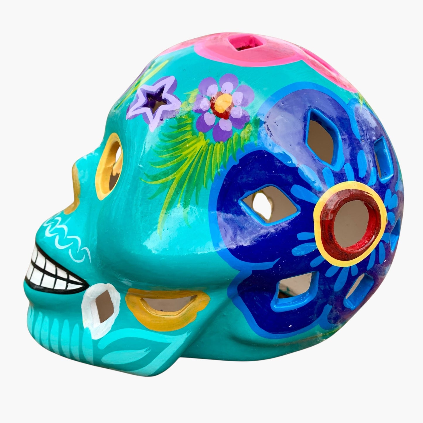 Colorful Mexican Sugar skull teal with vibrant designs on a white background side view