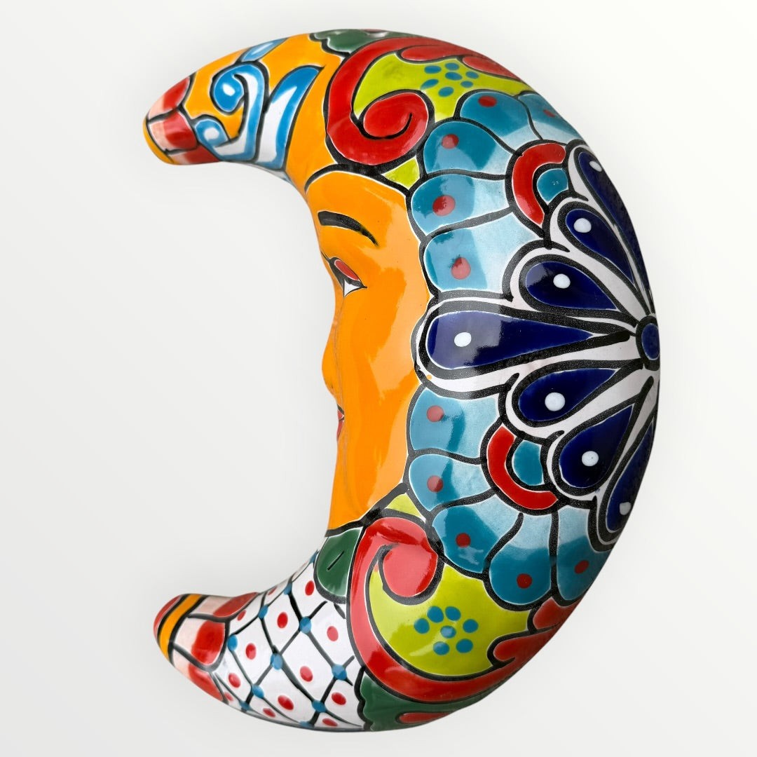 Colorful decorative crescent moon with intricate patterns on a white background curved side view
