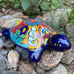 Colorful Mexican Talavera ceramic turtle figurine on a natural stone background
