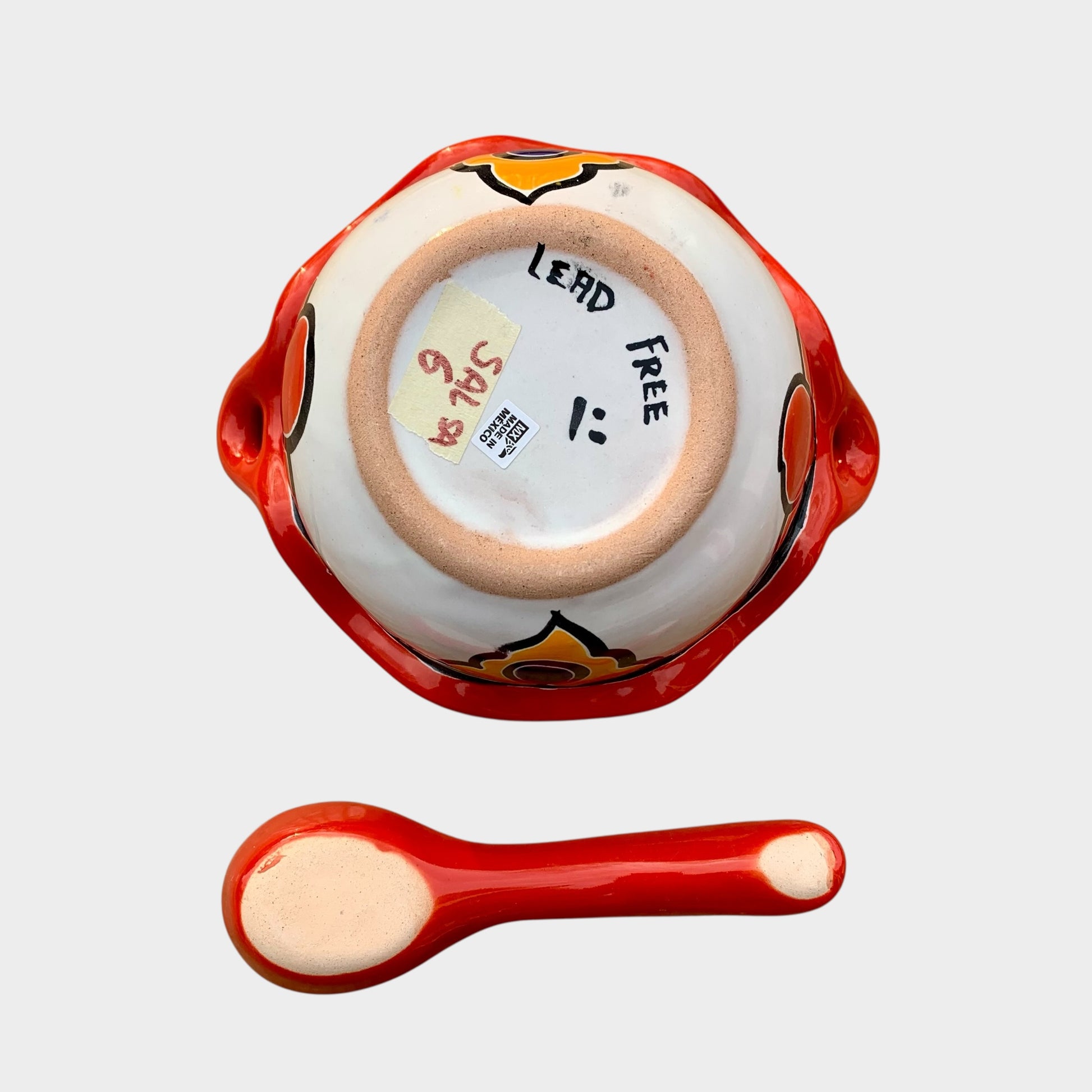 Colorful talavera salsa bowl with floral patterns and spoon on a white background Bottom