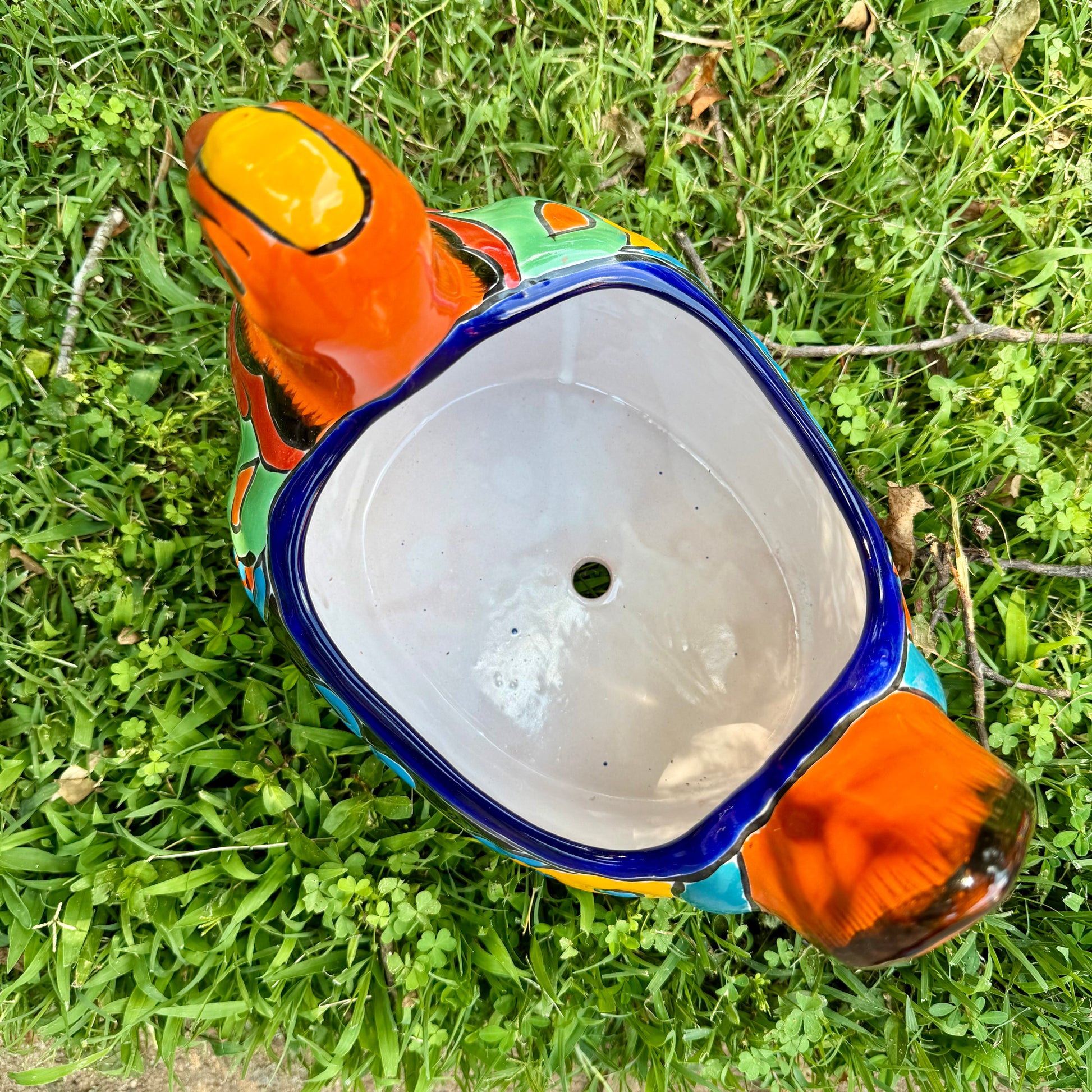 Colorful orange multi-color Mexican Talavera ceramic chicken shape planter on a natural background Top opening