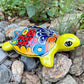Colorful Mexican Talavera ceramic turtle figurine on a natural stone background