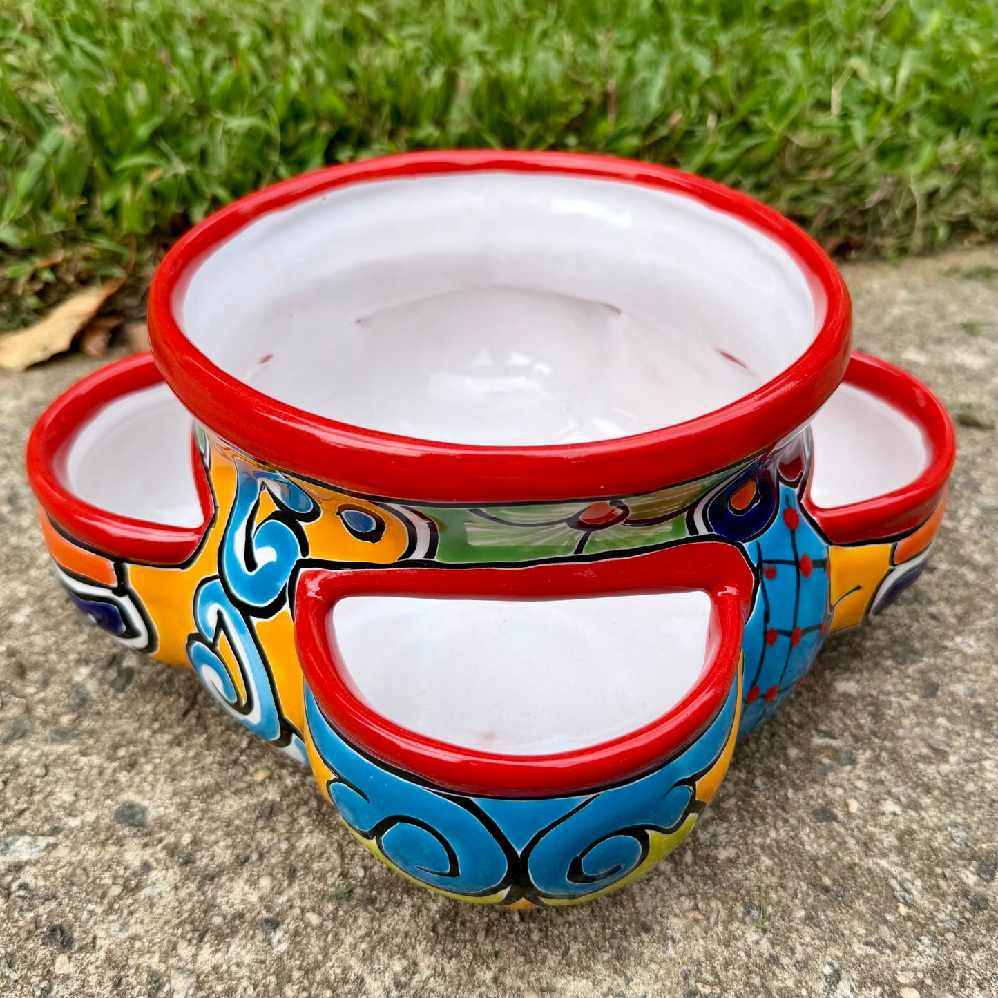 Hand painted Mexican Talavera Strawberry pot with a large top opening a four pockets on each side.  Trim color is cherry red, body has multi-color designs on each side.