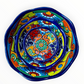 A set of three nested Talavera ceramic bowls with a vibrant hand-painted floral and geometric pattern in multiple colors, featuring a deep blue rim, shown on a plain white background.