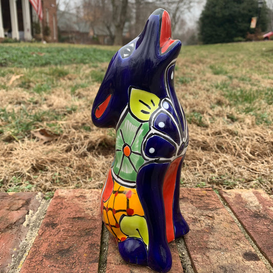 Colorful Talavera Coyote figure on a brick surface with a grassy area in the background