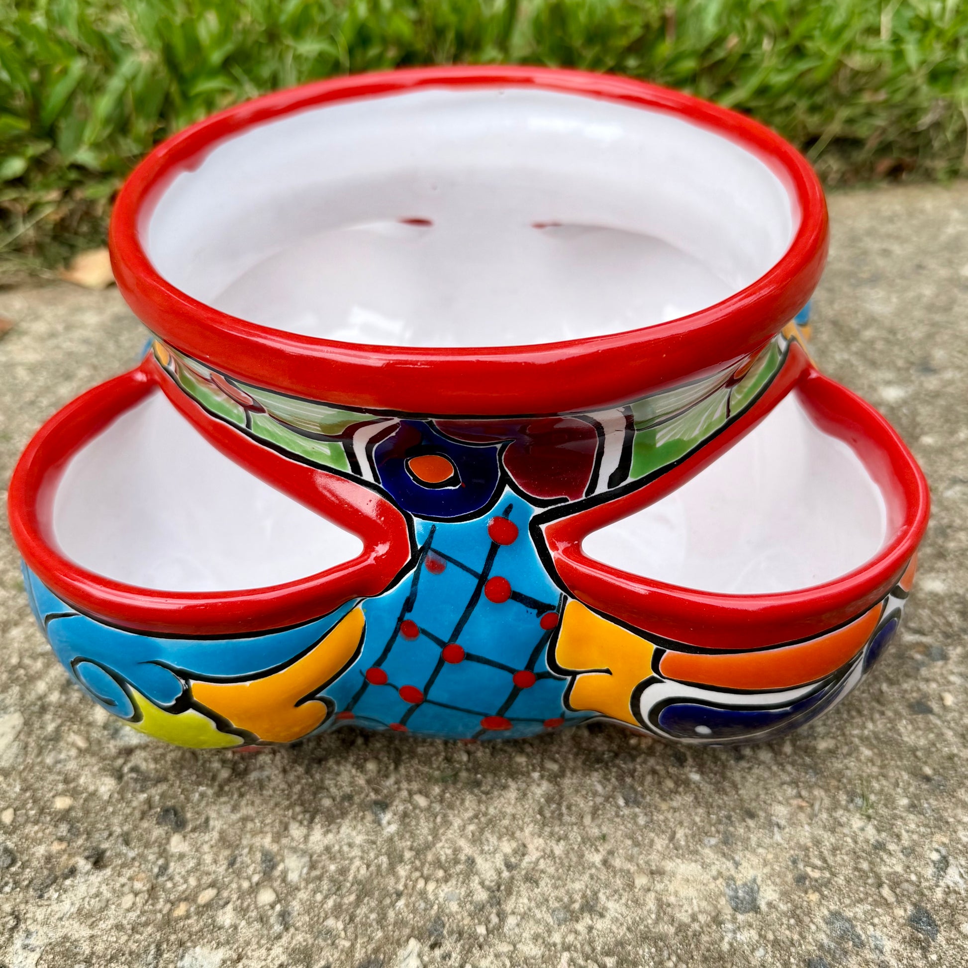 Hand painted Mexican Talavera Strawberry pot with a large top opening a four pockets on each side.  Trim color is cherry red, body has multi-color designs on each side. This is the side view.