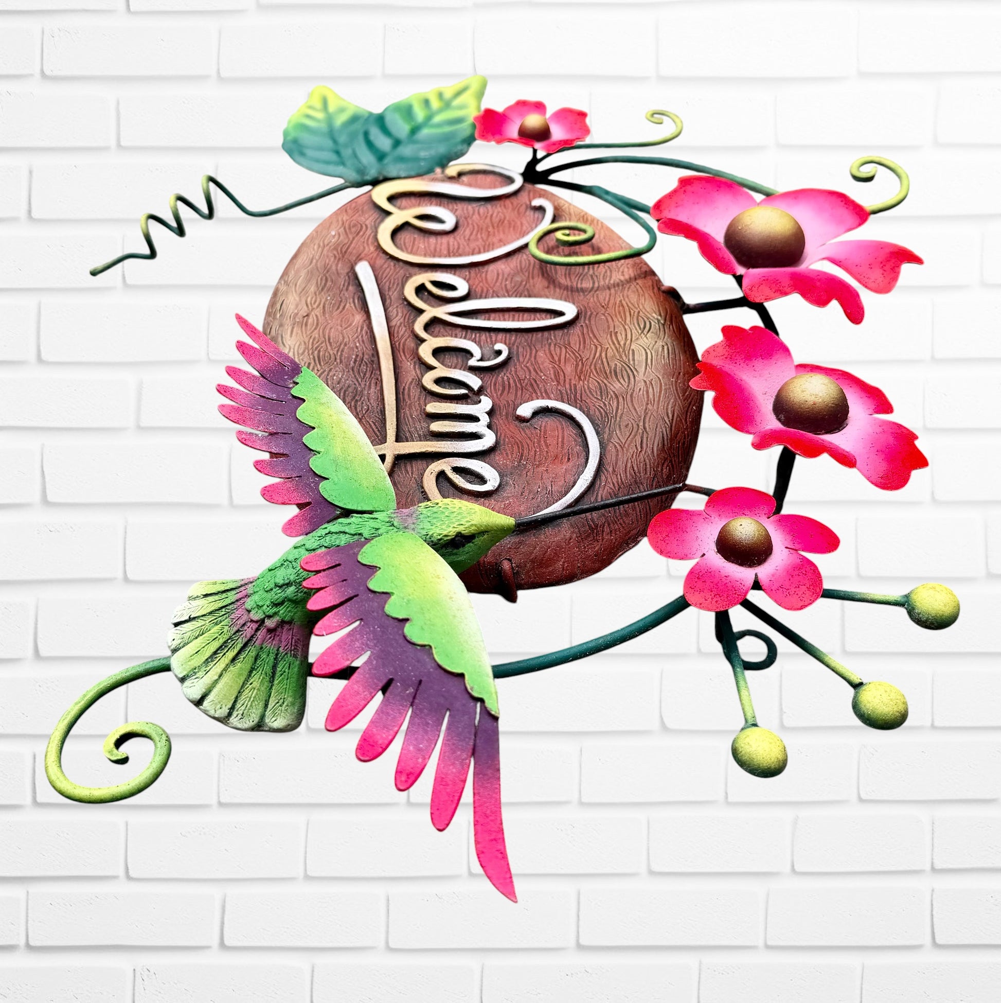 Decorative 'Welcome' sign with pink flowers and a hummingbird on a white brick wall background right side view