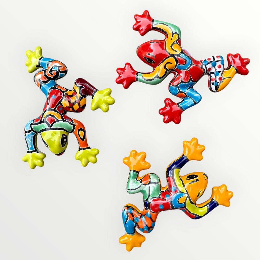 Three colorful ceramic frogs on a white background