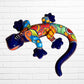 Colorful lizard-shaped wall art against a white brick wall background side