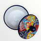 Mexican covered tortilla serving piece with blue rim and multi-color designs, top view of dish and cover.