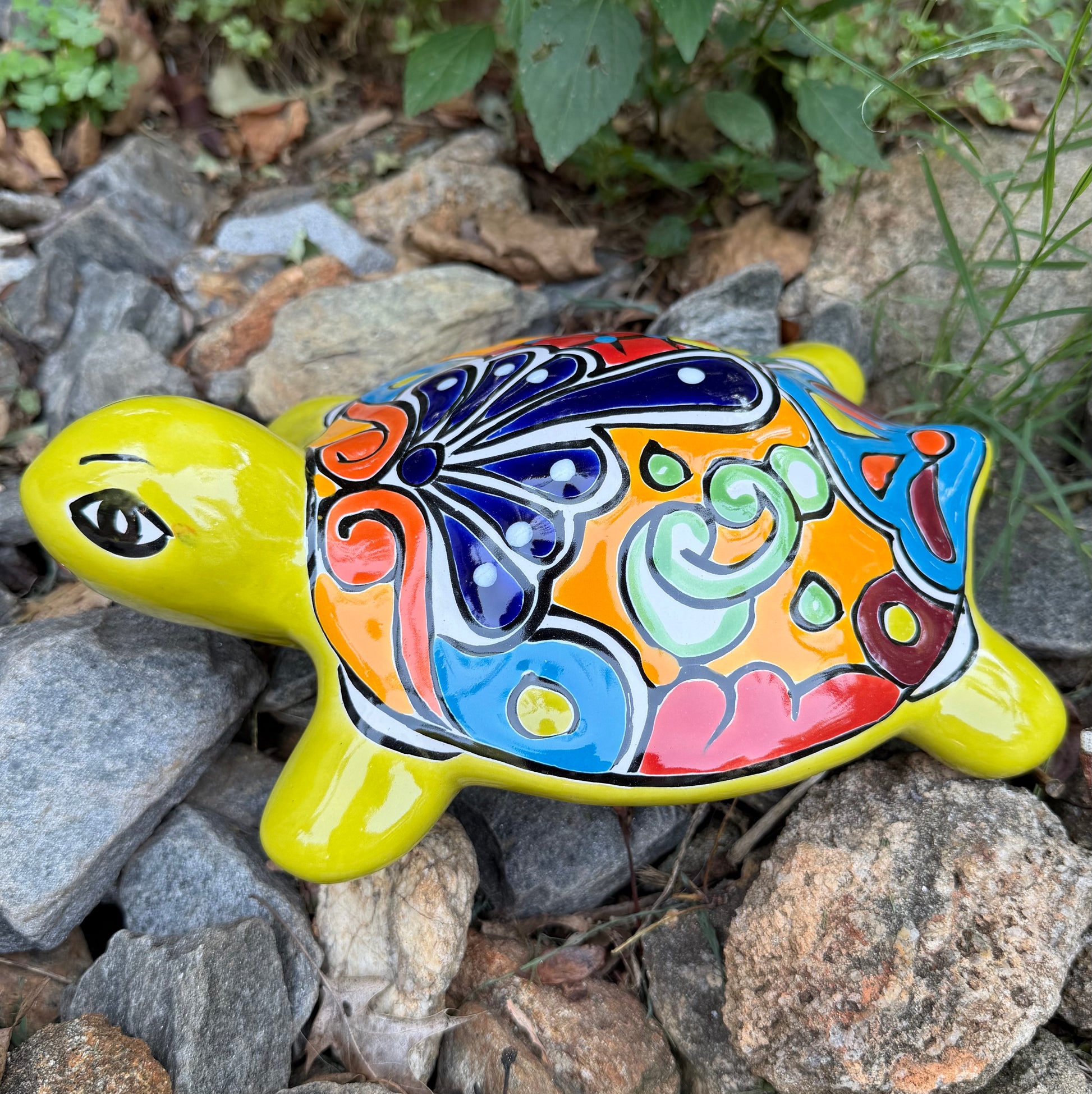 Colorful Mexican Talavera ceramic turtle figurine on a natural stone background Right side