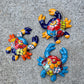 Three colorful hand-painted Talavera ceramic crabs arranged on a textured gray concrete surface.