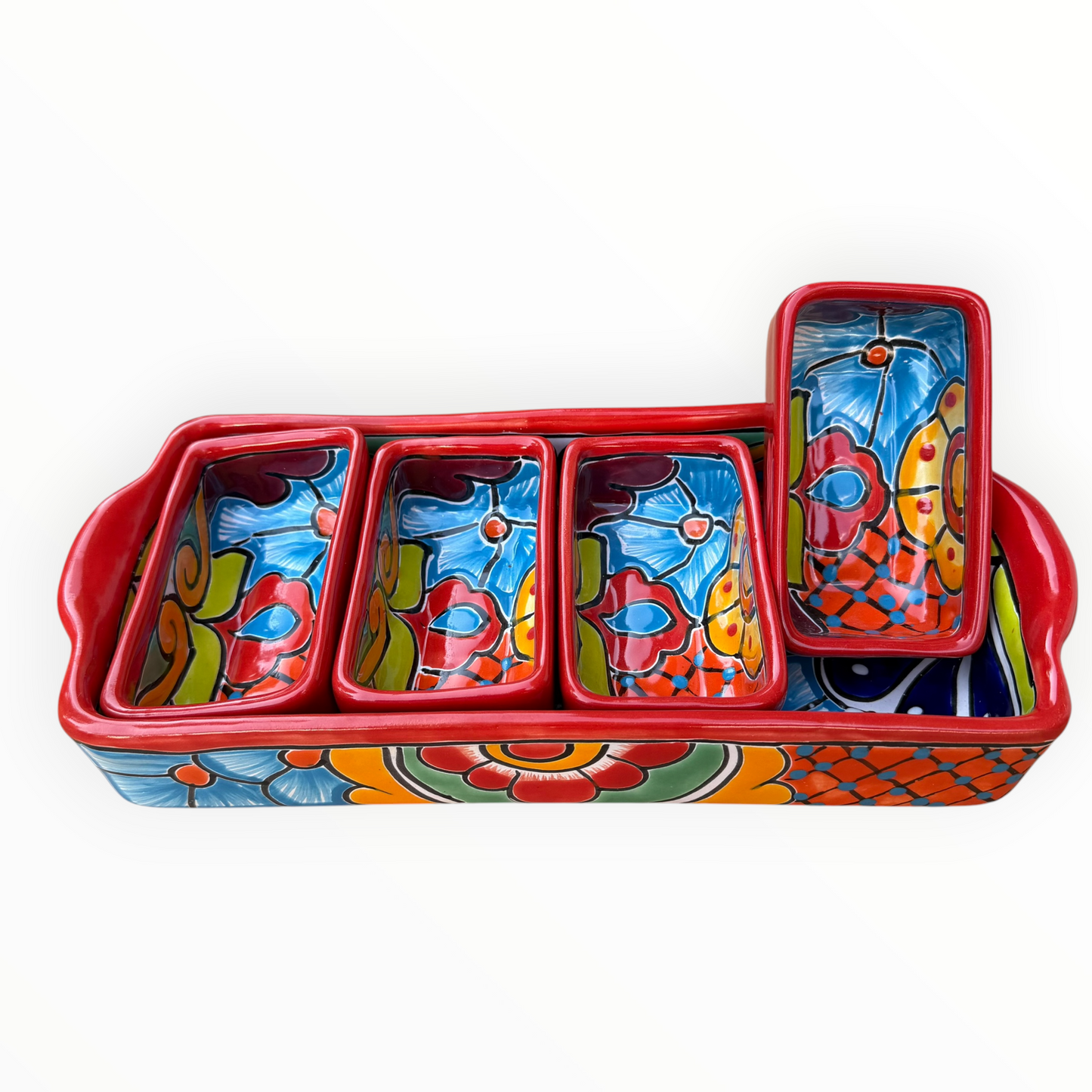 A red ceramic four-compartment serving tray with hand-painted talavera designs in blue, orange, green, and yellow on a white background, side view.