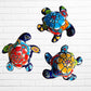 Three colorful hand-painted ceramic sea turtle wall art pieces displayed against a white painted brick wall.