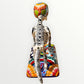 A talavera catrina dog skeleton figurine with colorful hand-painted floral and geometric patterns, standing on a matching decorated base against a plain white background. Back view of dog catrina showing backbone.