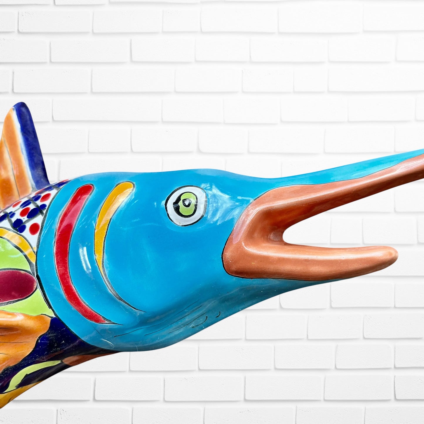 Colorful Mexican Talavera selfish sculpture against a white brick wall Face closeup 