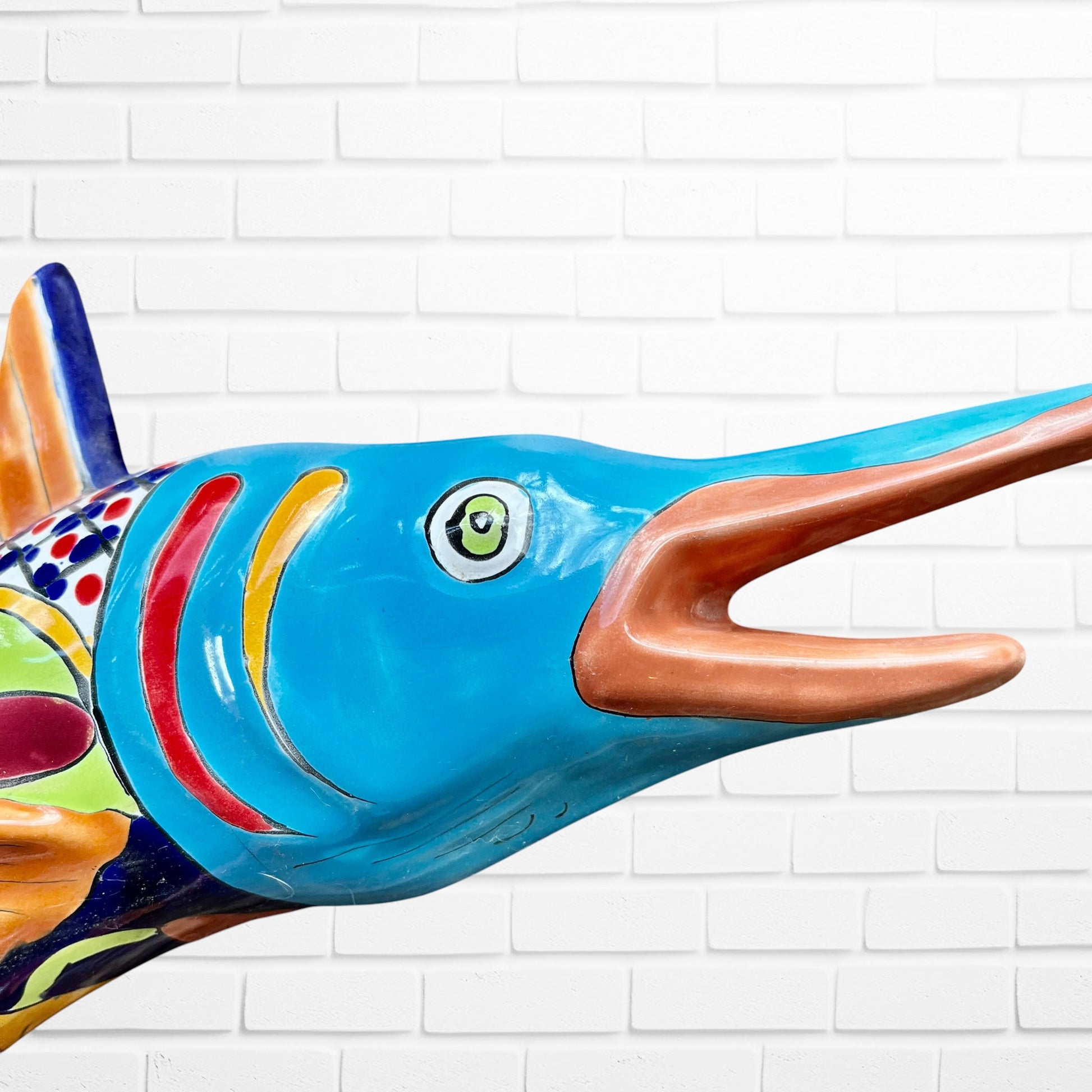 Colorful Mexican Talavera selfish sculpture against a white brick wall Face closeup 