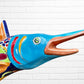 Colorful Mexican Talavera selfish sculpture against a white brick wall Face closeup 
