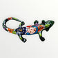 Mexican Talavera wall mounted iguana in dark green with multicolor designs left side view.