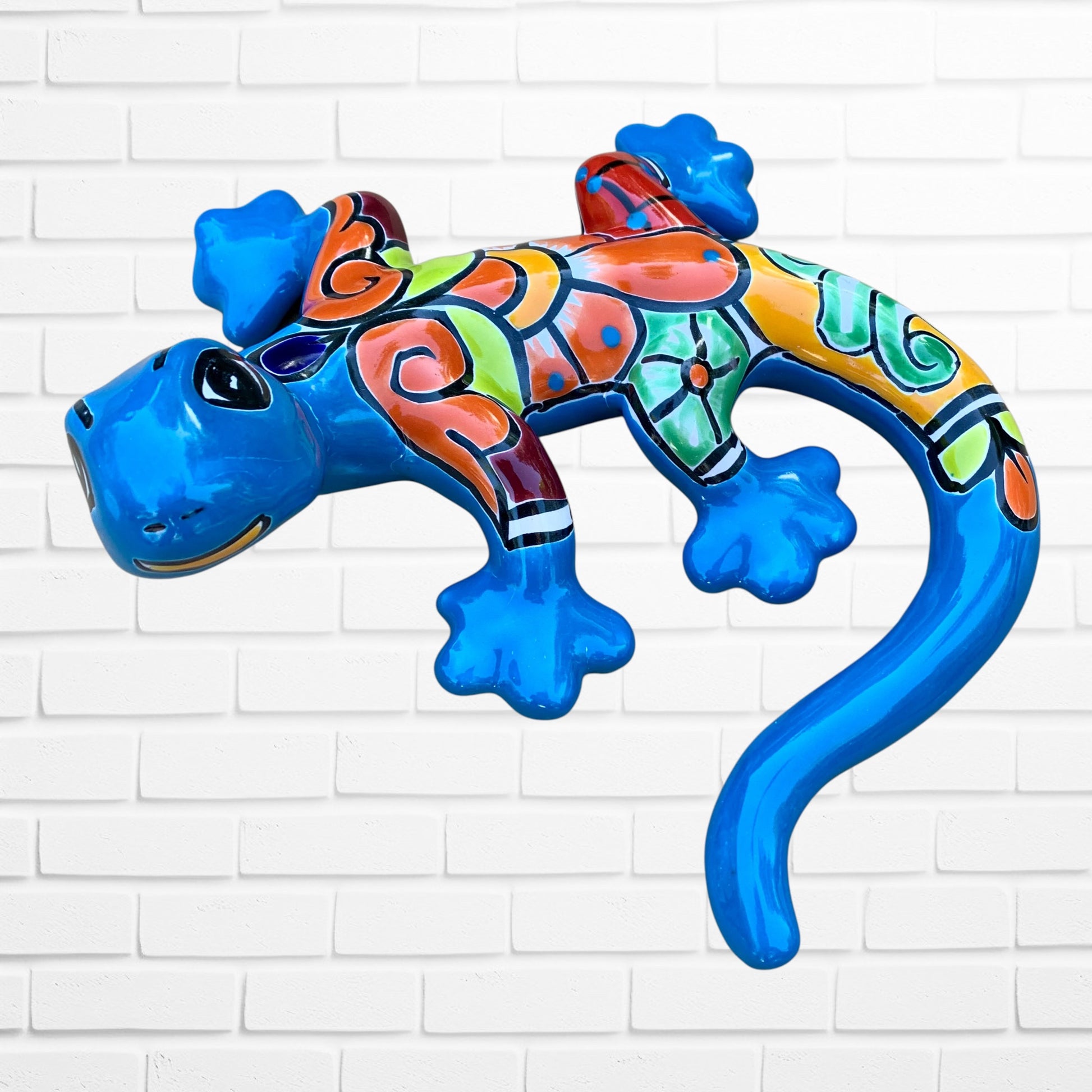 Colorful lizard toy against a white brick wall background side