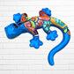 Colorful lizard toy against a white brick wall background side