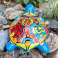 Colorful Mexican Talavera ceramic turtle figurine on a natural stone background Back